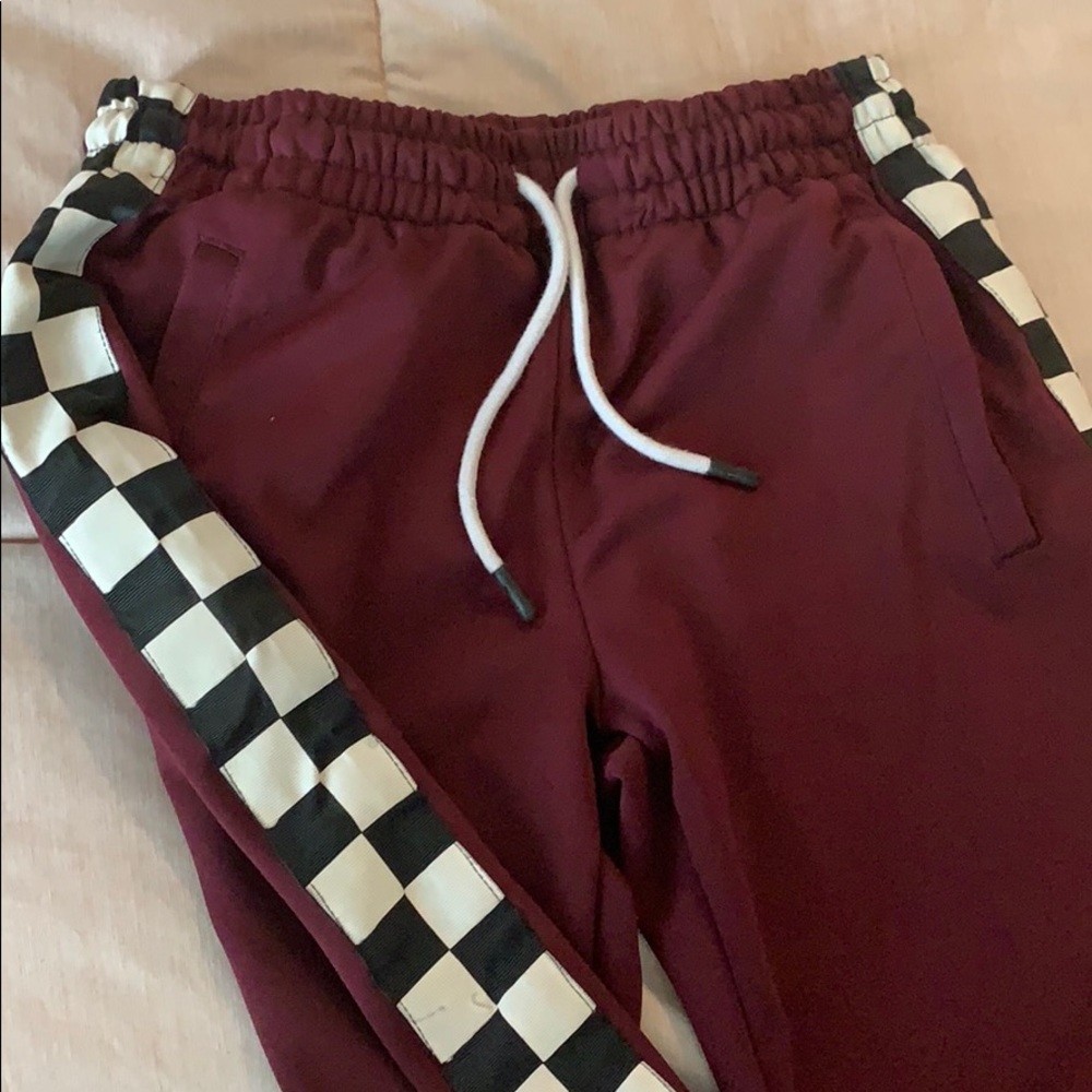 Maroon pants with checkered print along the sides
